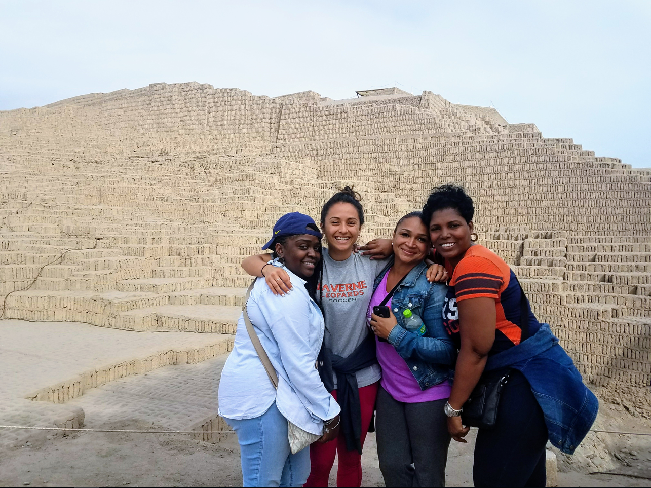 Four students in front of pyramids of Lima